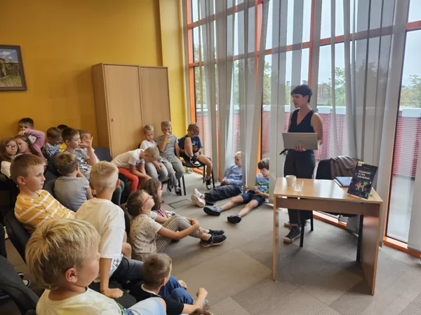 Linda Mence tiekas ar bērniem  bibliotēkā "Varavīksne".